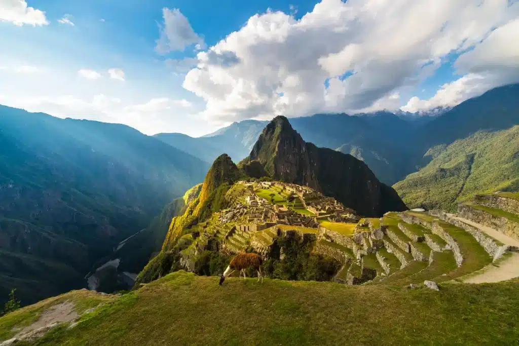 Panoramic view of Machu Picchu and the surrounding Andes mountains at sunset